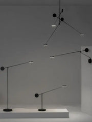 Black minimalist pendant and floor lamps featuring sleek adjustable swing arms and circular light fixtures