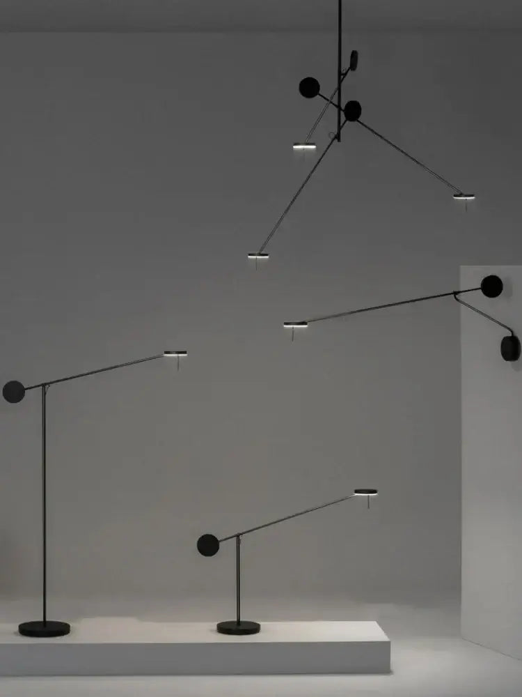 Black minimalist pendant and floor lamps featuring sleek adjustable swing arms and circular light fixtures