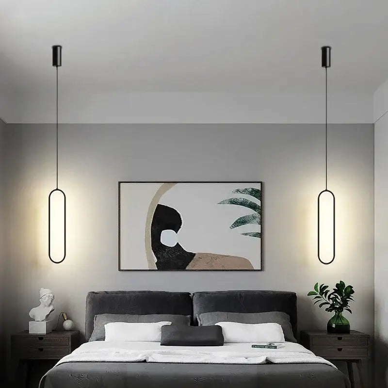 Modern black aluminium led chandelier with sleek elongated oval pendant lights hanging symmetrically above the bed