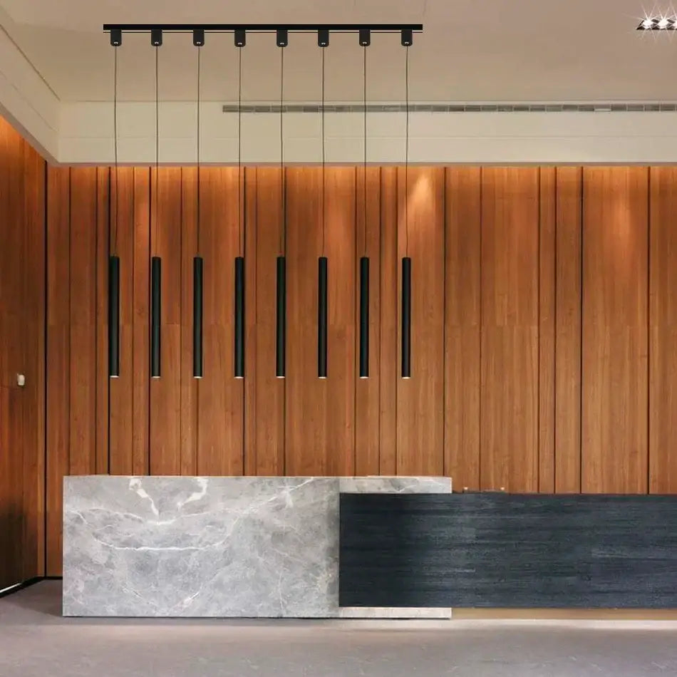 Modern reception desk with sleek gray marble and dark wood finish featuring minimalist black aluminum led ceiling rail track spotlights