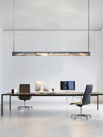 Minimalist black and amber marble design pendant light with sleek rectangular shape and warm ambient glow for office use