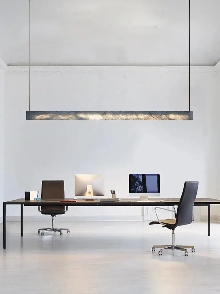 Minimalist black and amber marble design pendant light with sleek rectangular shape and warm ambient glow for office use