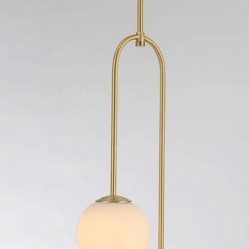Minimalist black bronze glass ball pendant light with gold-toned curved metal frame and frosted glass globe for living room decor