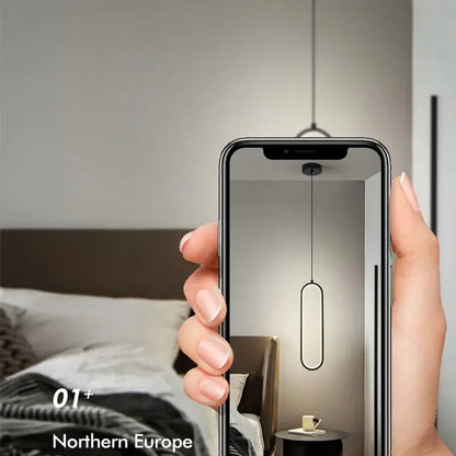 A sleek minimalist black built-in led pendant light with modern oval design hanging above a dining table
