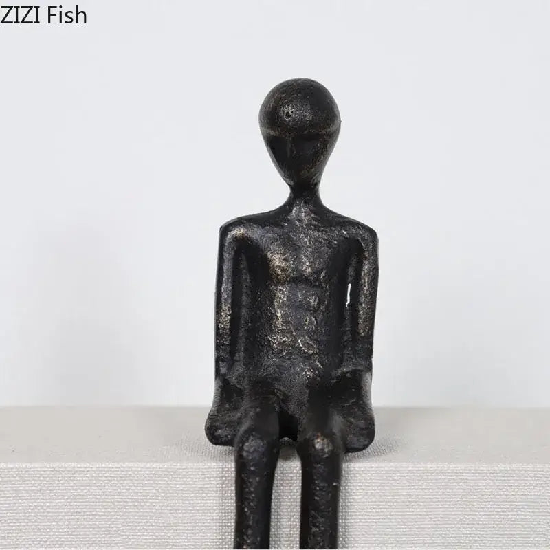 Minimalist black character metal statue of seated humanoid with matte finish, ideal as a metal statue desk ornament