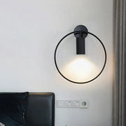 Minimalist black circular metal sconce with frosted glass diffuser for living room wall lighting