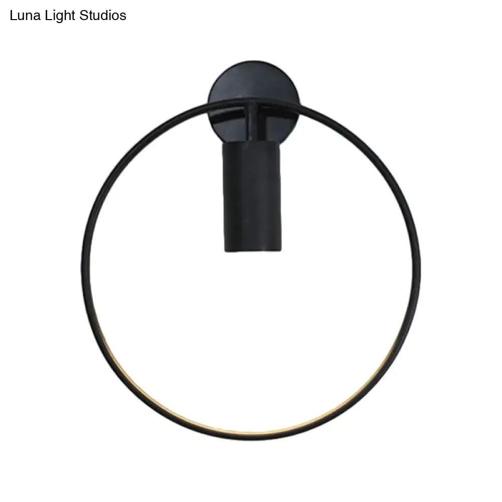 Minimalist black circular metal sconce with matte finish and gold accent for living room wall lighting