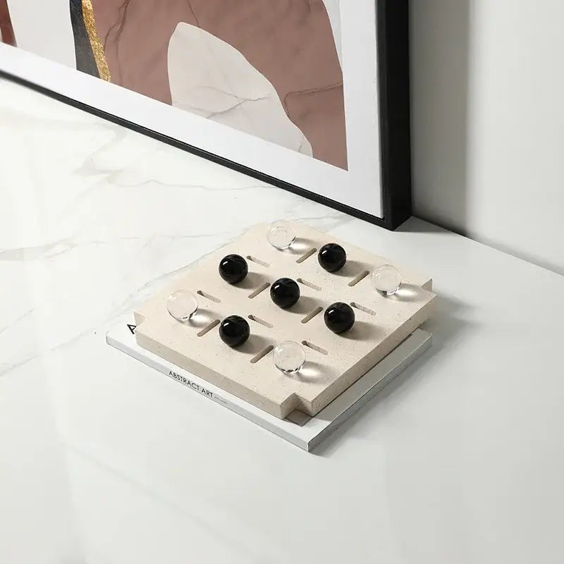 Minimalist black and clear geometric glass bead chess set with beige stone board for modern living room decorbites decor