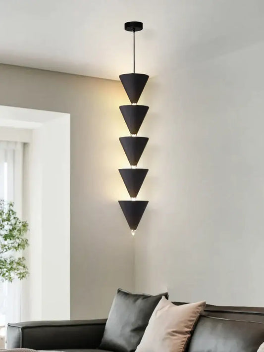 Minimalist black and cream bedroom chandelier with five stacked conical shades emitting warm ambient glow for decorbites cream bedroom decor