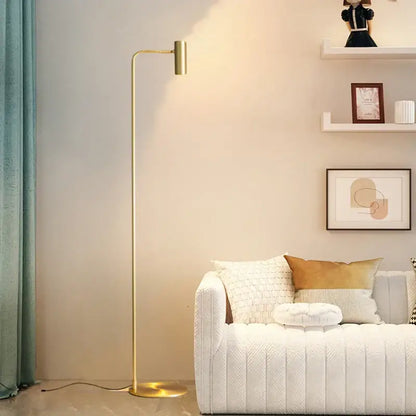 A sleek gold-finished decorbites brass floor light with a minimalist curved arm ideal for bedroom decor