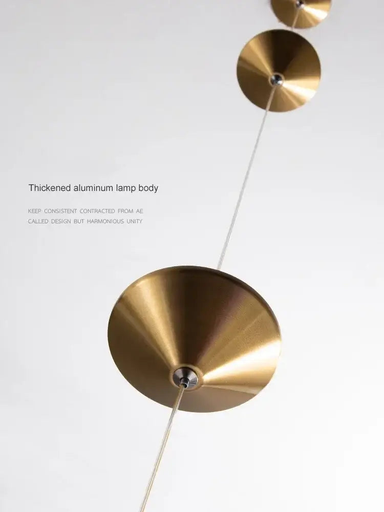 A minimalist black floor lamp featuring stacked brass conical shades with decorbites cone design art suspended by cables