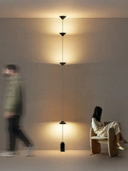 A minimalist black decorbites cone design floor lamp with three conical shades suspended by cords for living room lighting