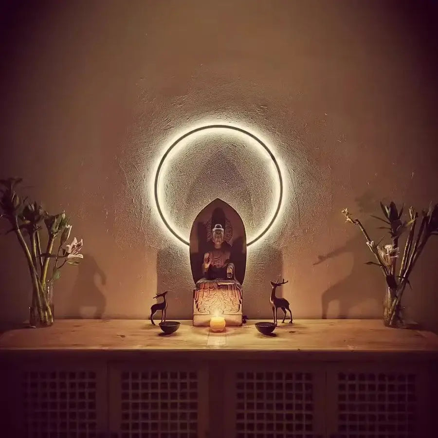 A serene buddha statue with intricate golden detailing beneath a minimalist black decorbites designer ring led wall light