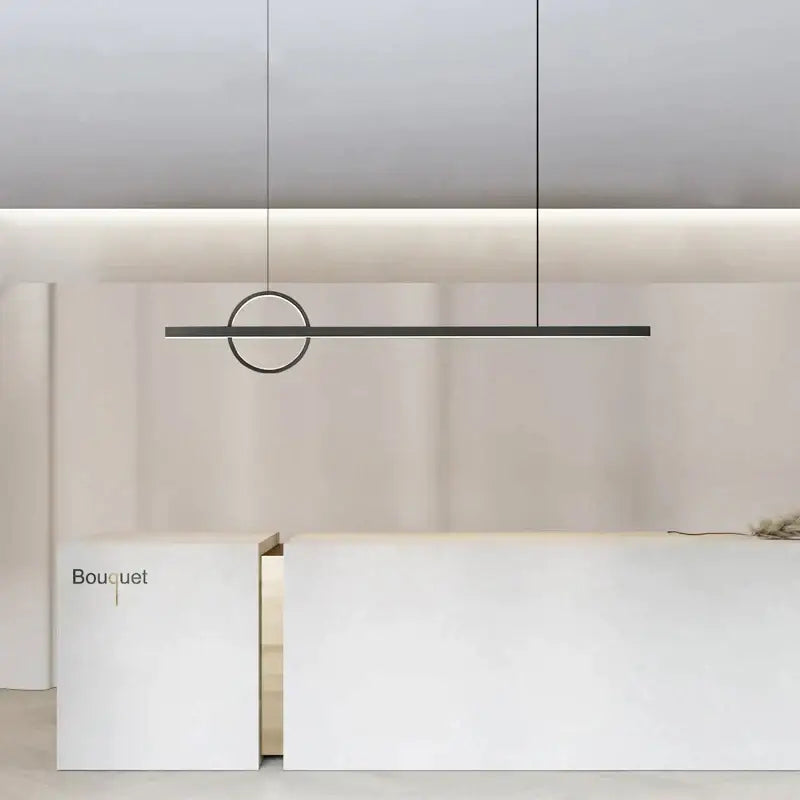 Minimalist black geometric copper chandelier pendant light with circular accent hanging above white reception desk decorbites geometric copper