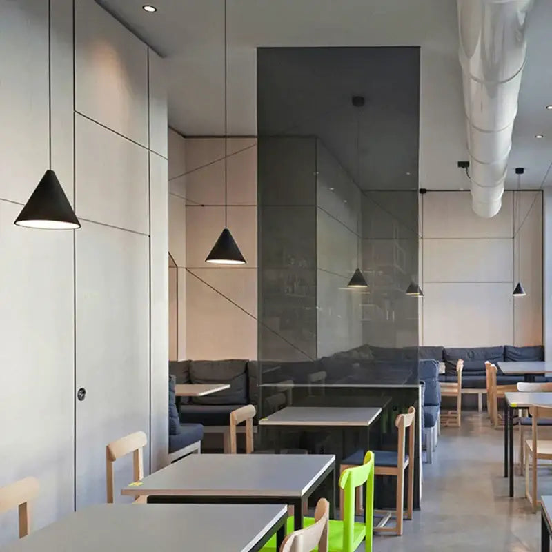 Minimalist black geometric led pendant light with sleek conical design in a modern café setting decorbites geometric led pendant