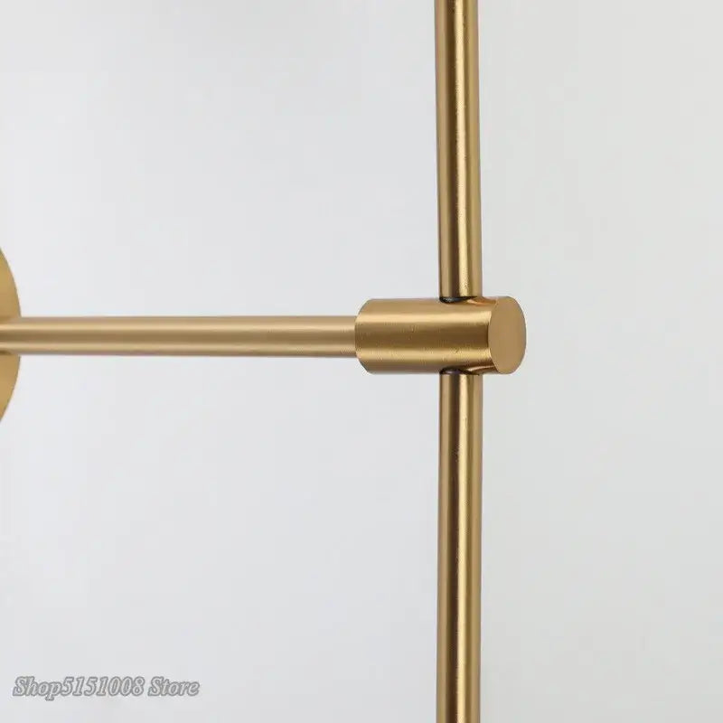 Gold-toned metal wall-mounted towel rack with sleek minimalist design paired with decorbites glass ball led wall lamp bedroom sconce