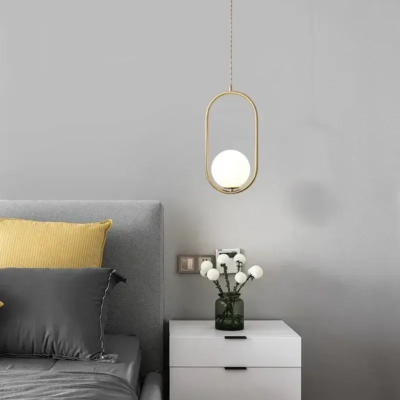 Minimalist pendant lamp with a gold-toned oval frame and frosted black glass ball globe for dining room decorbites glass ball