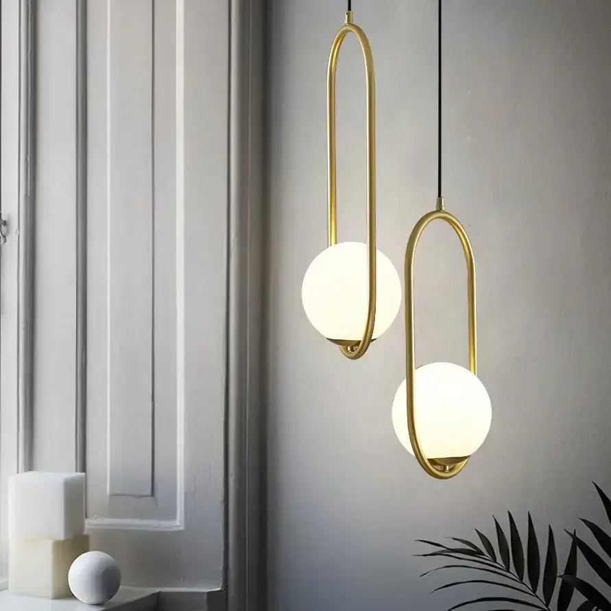 Two modern pendant lamps with gold-toned metal frames and frosted glass ball spheres for dining room decorbites glass ball