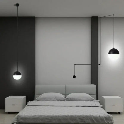Minimalist black glass ball pendant light with sleek design hangs above bed in contemporary bedroom decorbites glass ball pendant