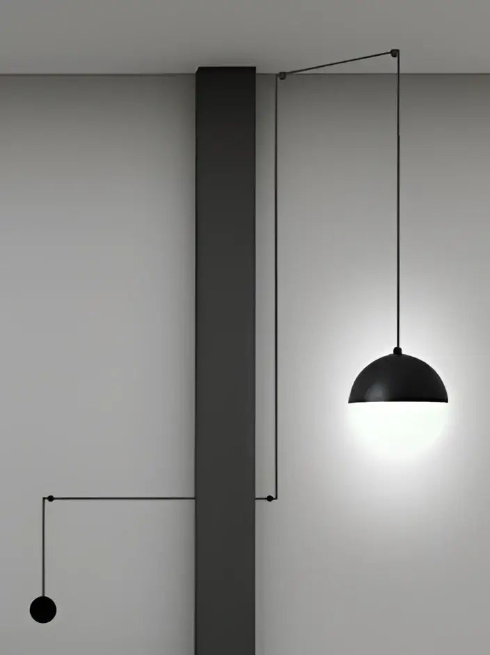 Minimalist black glass ball pendant light with a sleek dome design hanging from an adjustable arm by decorbites