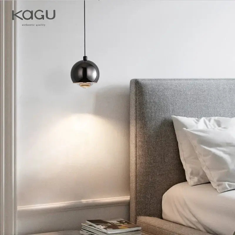 Minimalist black glossy pendant light with reflective finish and warm bulb, ideal for bedroom and kitchen island decorbites gold metal luster