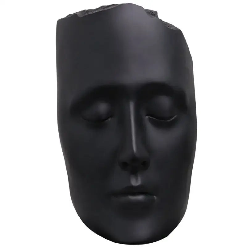 Minimalist black matte abstract face sculpture with serene expression and gold accents for living room decor