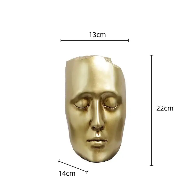 Minimalist black and gold abstract face sculpture featuring a golden metallic mask with smooth, stylized features for decor