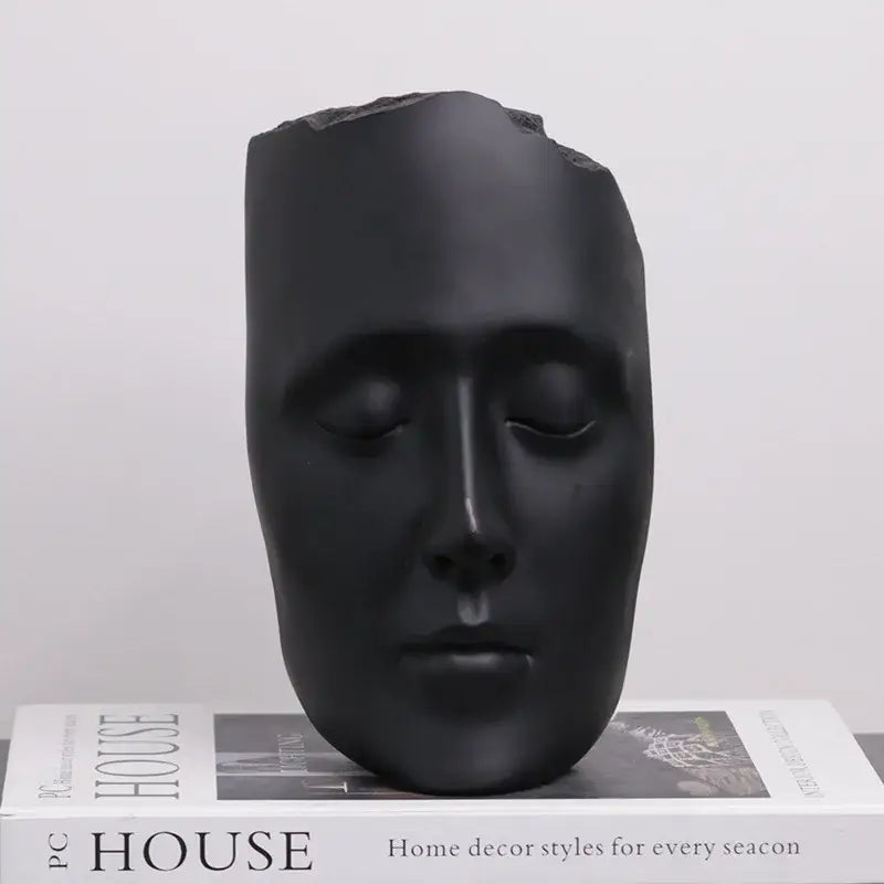 Minimalist black matte abstract face sculpture with smooth design and gold accents for living room decor