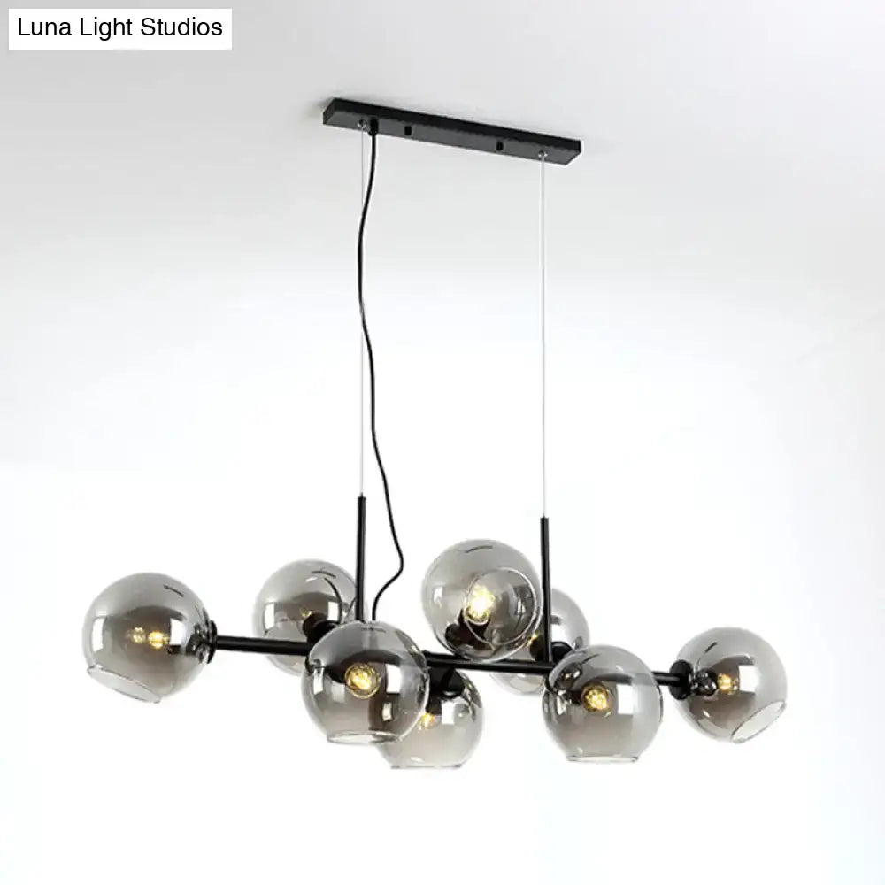 Minimalist black and gold metal chandelier with clear smoke grey glass globes for dining room lighting