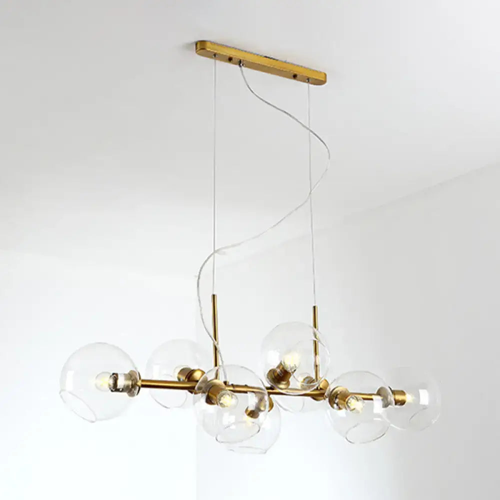 Modern brass chandelier with clear smoke grey glass globe shades for minimalist black and gold dining room lighting