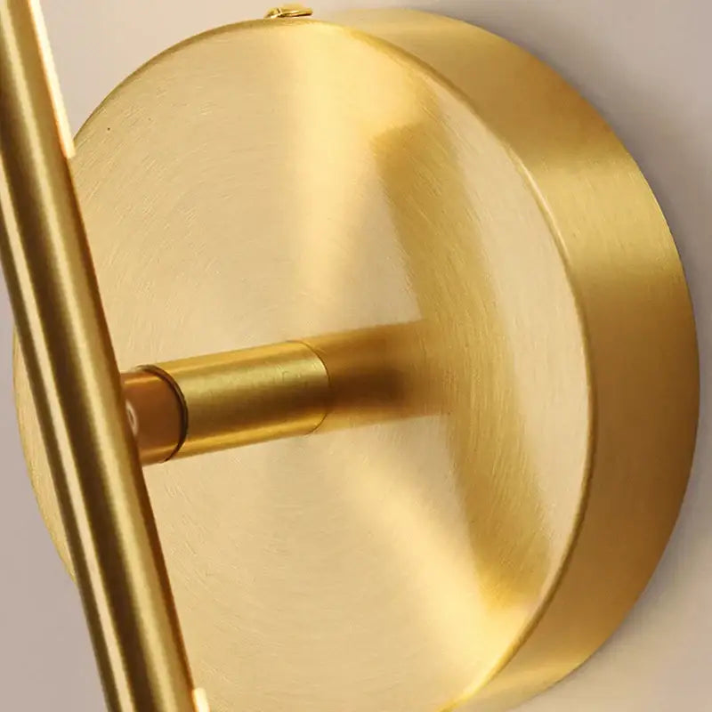 Minimalist black and gold copper wall sconce lamps with gold-finished brass and sleek circular base for bathroom use