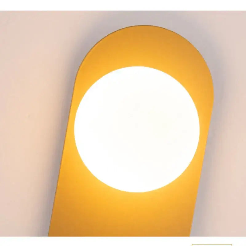 Modern yellow wall sconce with circular illuminated center and smooth edges from decorbites glass ball led collection