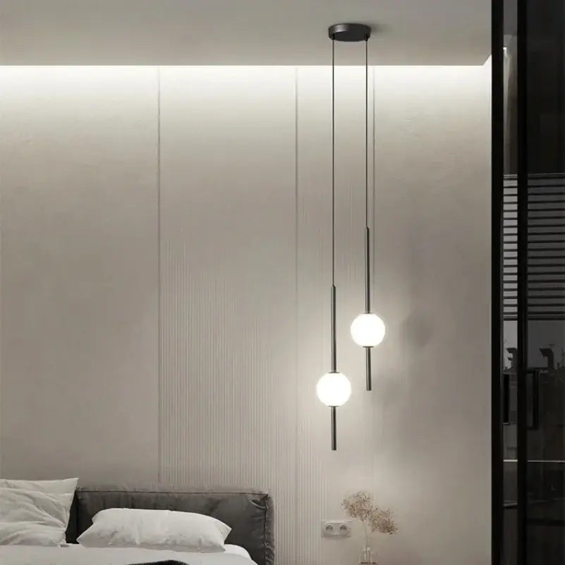 Minimalist black and gold globe pendant light with sleek black metal rods and white glass shades for dining room use