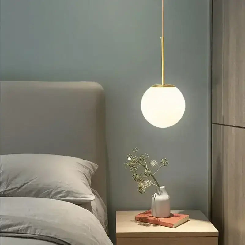A minimalist black and gold globe pendant light with frosted glass and led bulb for modern kitchen lighting