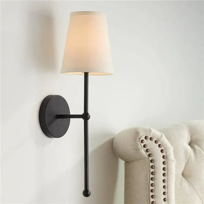 Minimalist black wrought iron led wall lamp with cream fabric shade for bedroom lighting and decor