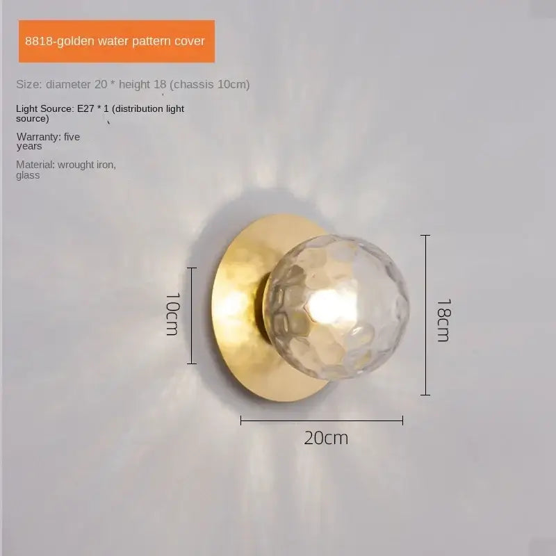 Minimalist black and gold led wall lamp with a golden faceted glass globe and circular wrought iron base for living room