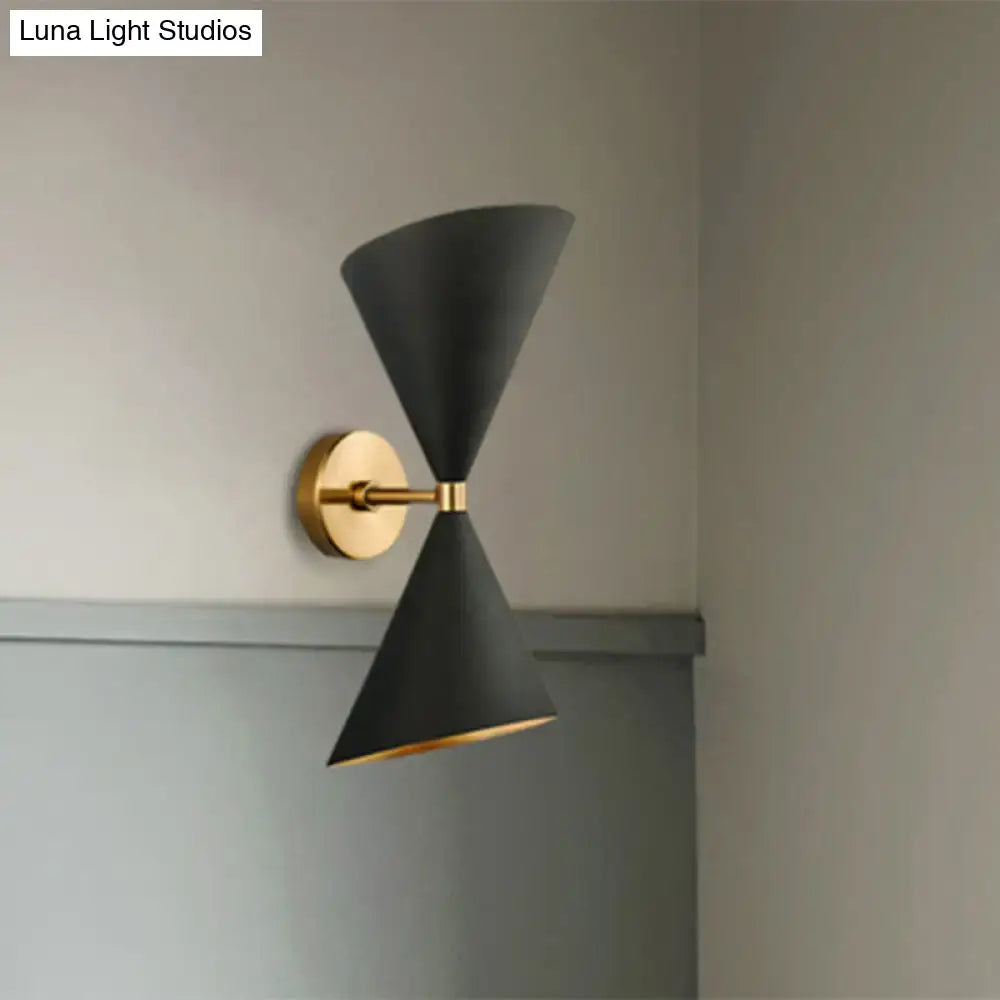 Minimalist black wall lamp with two double cone-shaped shades and gold-toned brass hardware for bedroom use
