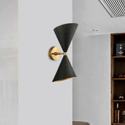 Minimalist black wall lamp with two double cone-shaped shades and gold-toned metal accents for bedroom lighting