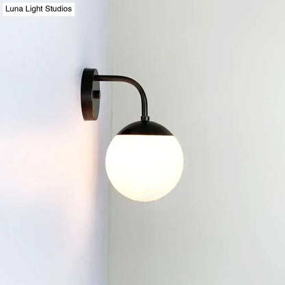 Black metal wall light featuring a minimalist golden black design with a milky glass ball for bedroom use