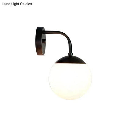 Black metal wall light with minimalist golden black finish and frosted milky glass ball for bedroom lighting