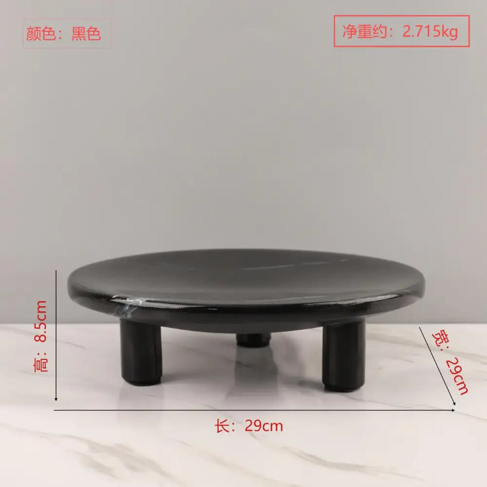 Black circular fruit tray with three short cylindrical legs in minimalist imitation marble decorbites imitation marble style