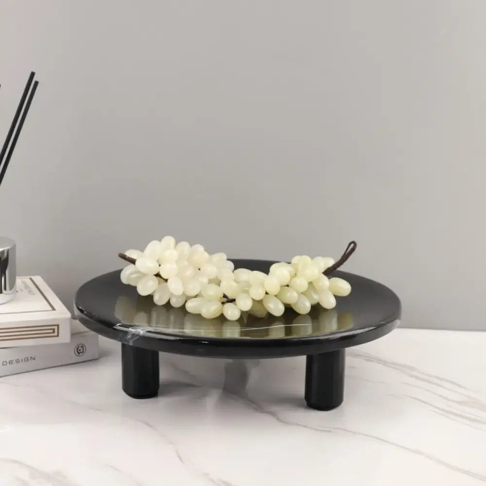 Minimalist black imitation marble fruit tray with two legs holding white faux grapes for dining room decorbites imitation marble