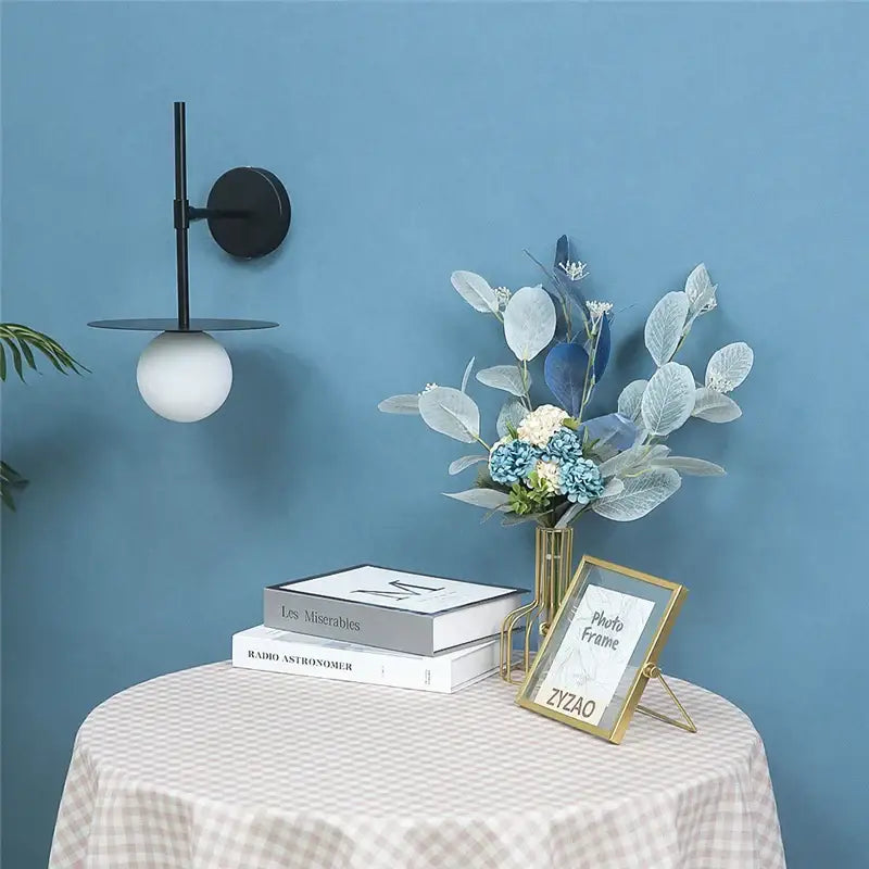 Minimalist black iron glass led wall light with circular base and frosted globe for bedroom and living room decorbites wall light