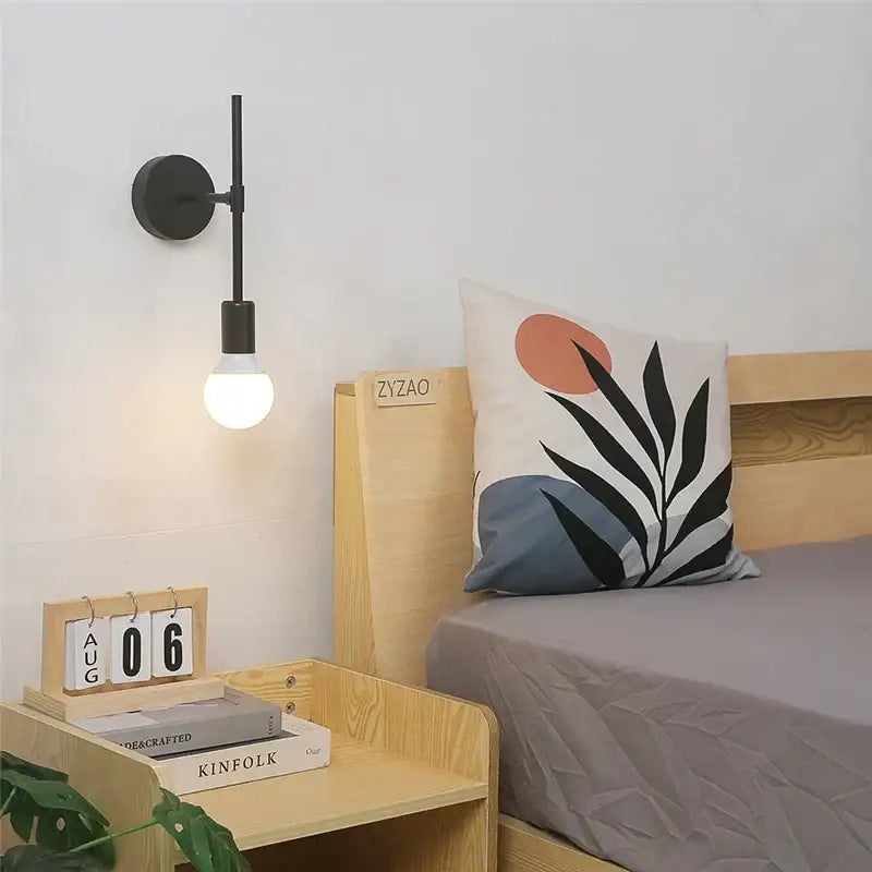 Minimalist black iron glass led wall light with slender vertical arm and frosted bulb for bedroom and living room decorbites