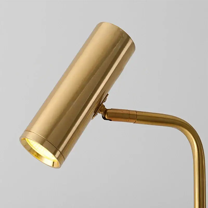 Brass cylindrical desk lamp with curved arm and warm light complementing minimalist black enna led dimmable floor lamp