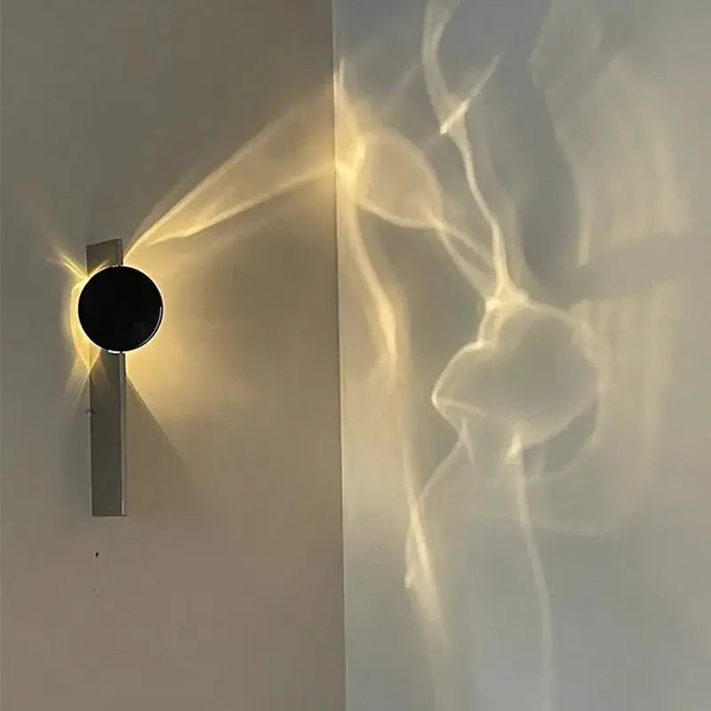 Minimalist black led wall sconce with sleek circular face and metallic base casting warm ambient light decorbites led wall