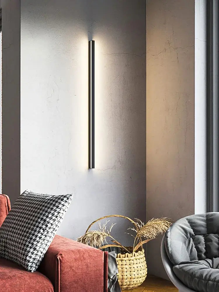 A sleek minimalist black linear LED wall lamp with slim vertical design providing warm glow for bedroom wall use