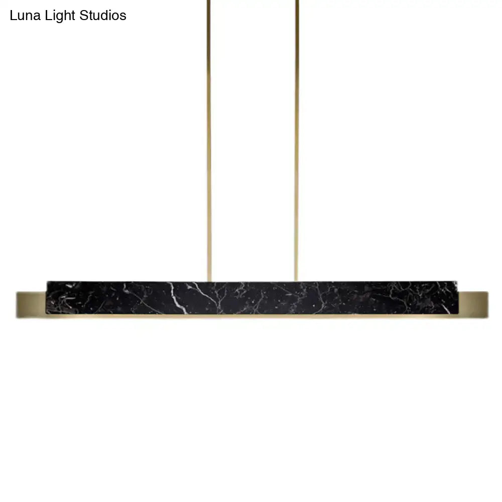 Minimalist black marble rectangular pendant light with gold metal accents and black cord for dining room use