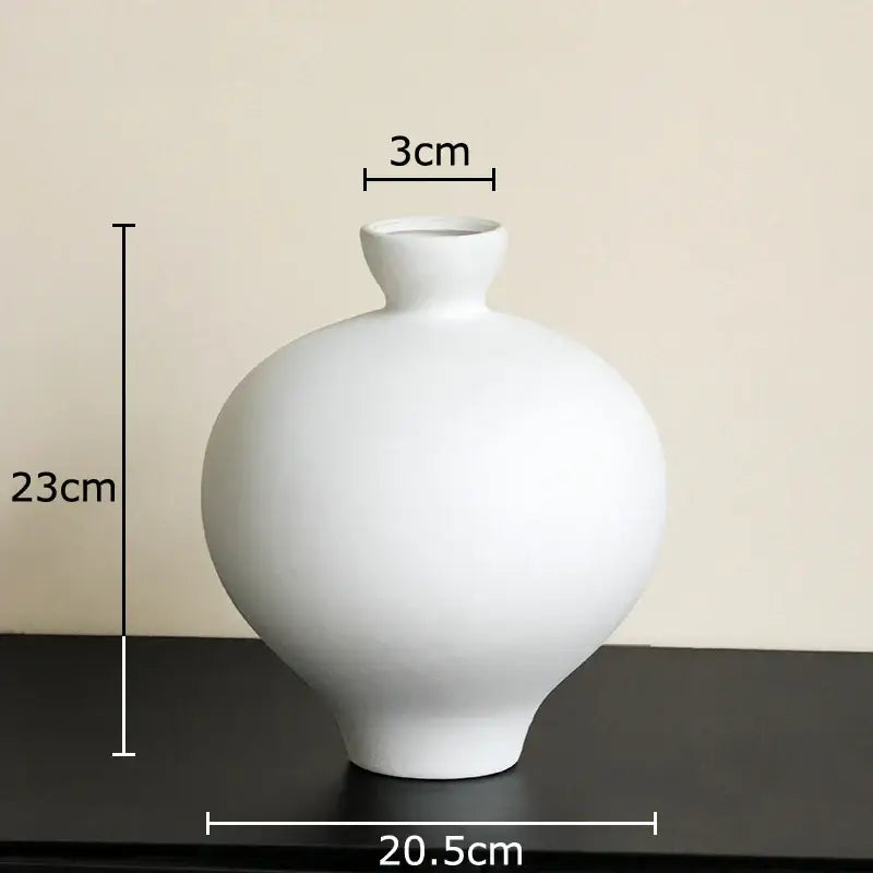 A sleek minimalist white ceramic big belly vase with a narrow neck for elegant living room decor