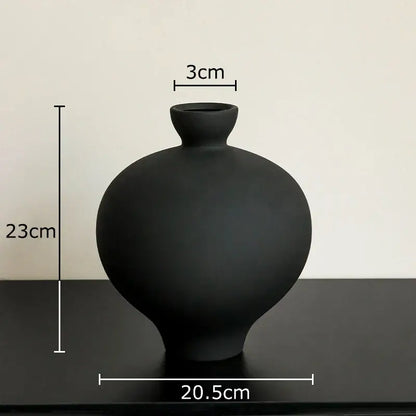 A sleek matte black big belly ceramic vase with rounded body and narrow neck for minimalist living room decor